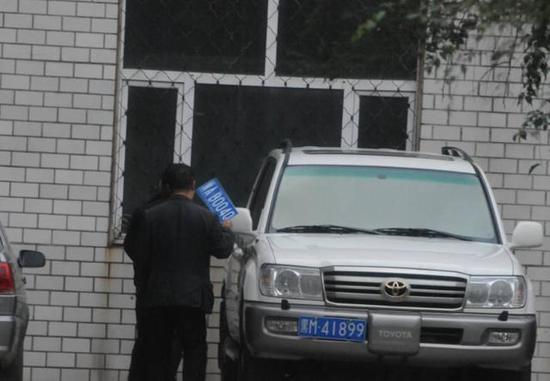 程父與程的“司機(jī)”在居住小區(qū)內(nèi)將黑AB0040車牌更換為黑M41899車牌，倆車牌號均為空號