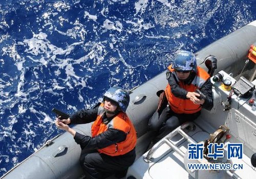 　3月28日，十余名臨檢拿捕隊員乘小艇駛至模擬可疑商船下方水面。