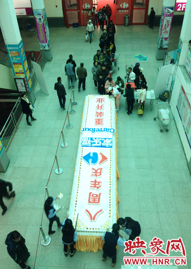 擺放在家樂福鄭州北環(huán)店內(nèi)義賣的巨型蛋糕