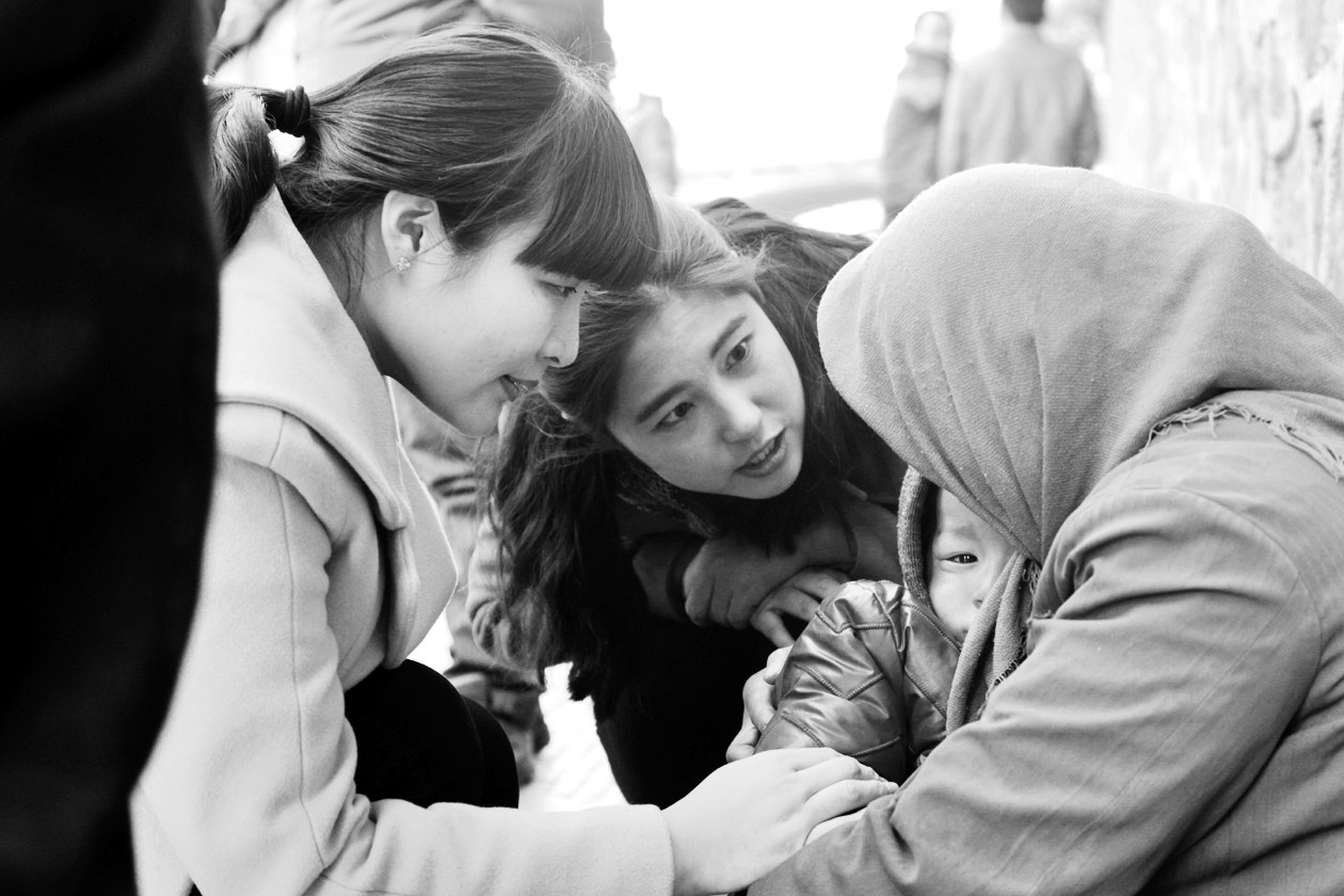 “幫女郎”(左)和“小莉”發(fā)現(xiàn)乞討男童后，上前近距離進(jìn)行辨認(rèn)