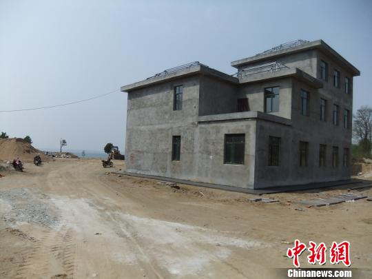 鴨河水庫庫區(qū)邊的新建別墅，一面墻上寫著“拆”，另一邊在加緊施工。吳揚(yáng)　攝